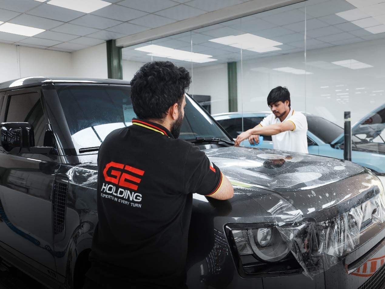 GE Holding technicians applying paint protection film in a dust-controlled Dubai workshop